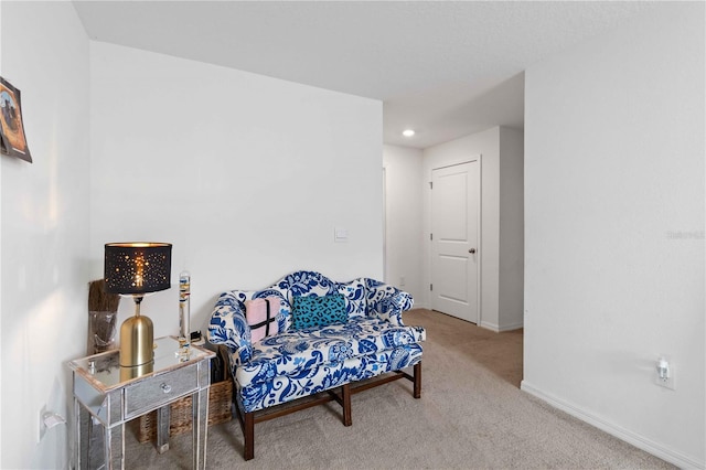 sitting room featuring light colored carpet