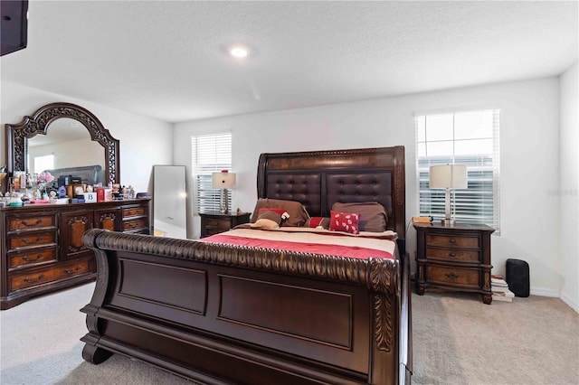 bedroom with light carpet and a textured ceiling