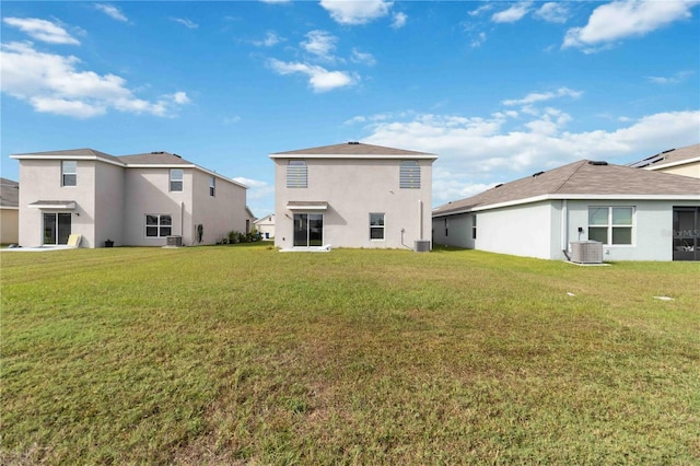 back of property featuring central AC and a yard