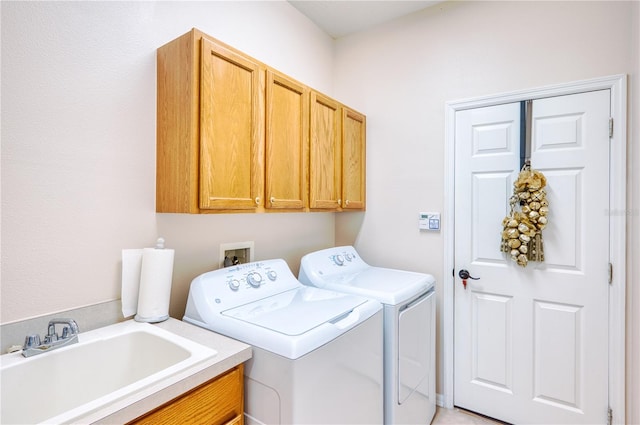 clothes washing area featuring separate washer and dryer, sink, and cabinets