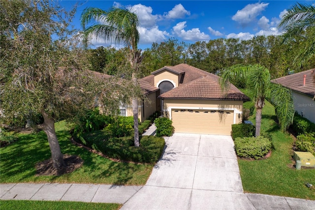 mediterranean / spanish house with a front yard and a garage