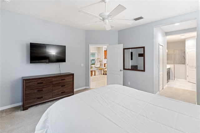 carpeted bedroom with ensuite bathroom and ceiling fan