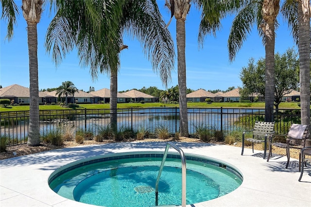 view of swimming pool with an in ground hot tub and a water view