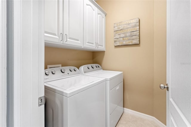 washroom featuring cabinets, washing machine and dryer, and light tile patterned flooring