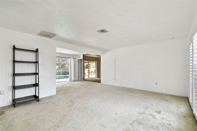 carpeted spare room featuring a textured ceiling