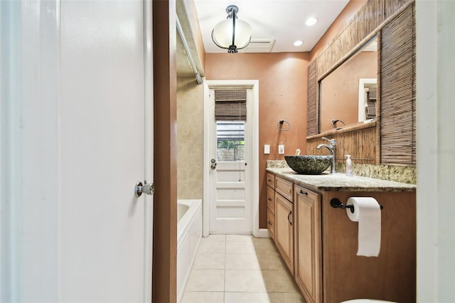 bathroom with tile patterned flooring, vanity, and a tub