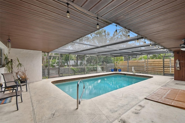 view of swimming pool with glass enclosure and a patio area