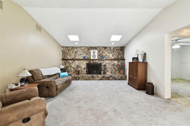 carpeted living room with a stone fireplace, lofted ceiling, and a textured ceiling