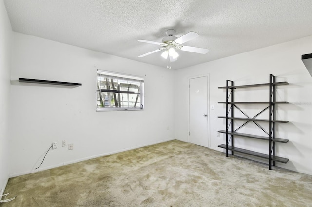 carpeted spare room featuring a textured ceiling and ceiling fan