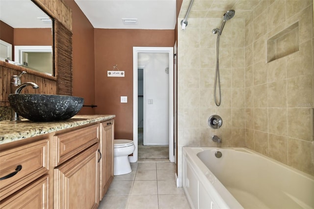 full bathroom with toilet, tile patterned flooring, vanity, and tiled shower / bath