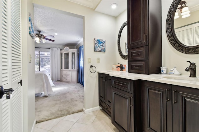 bathroom featuring vanity, a textured ceiling, ceiling fan, crown molding, and tile patterned flooring