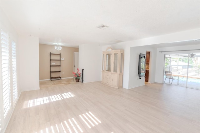 117 Hillcrest Dr, Bradenton, FL 34209 - unfurnished living room with a chandelier, visible vents, and light wood finished floors