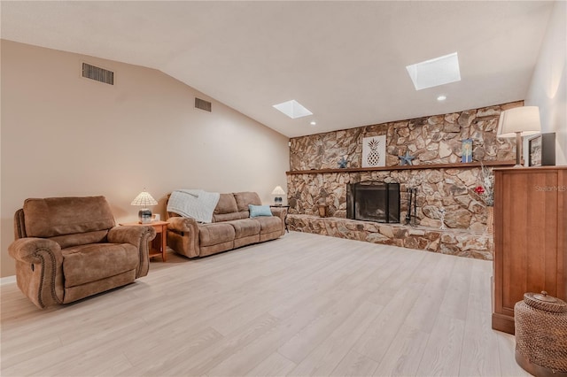 117 Hillcrest Dr, Bradenton, FL 34209 - living room with a stone fireplace, visible vents, lofted ceiling with skylight, and light wood finished floors