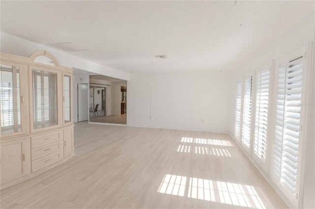 117 Hillcrest Dr, Bradenton, FL 34209 - unfurnished living room featuring visible vents, a textured ceiling, and light wood finished floors