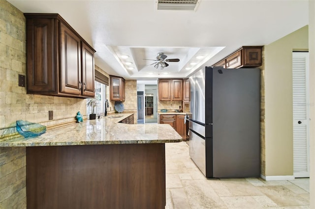 117 Hillcrest Dr, Bradenton, FL 34209 - kitchen featuring freestanding refrigerator, ceiling fan, a tray ceiling, a sink, and backsplash