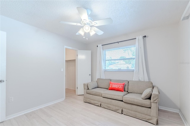 117 Hillcrest Dr, Bradenton, FL 34209 - living room with baseboards, a ceiling fan, light wood-style flooring, and a textured ceiling
