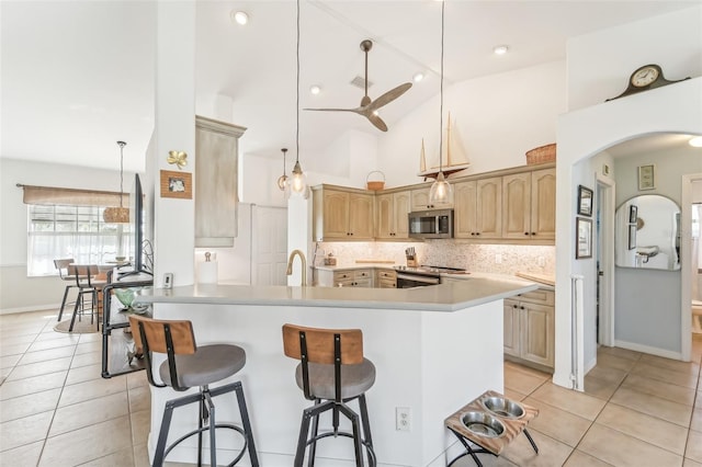 kitchen featuring kitchen peninsula, ceiling fan, pendant lighting, and stainless steel appliances