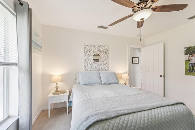 carpeted bedroom with multiple windows and ceiling fan