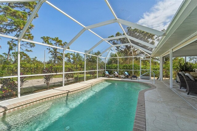 view of swimming pool featuring a lanai and a patio