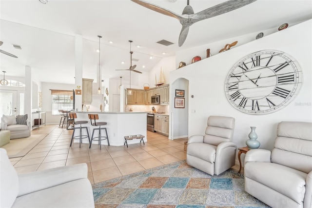 living room featuring light tile patterned floors, vaulted ceiling, and ceiling fan