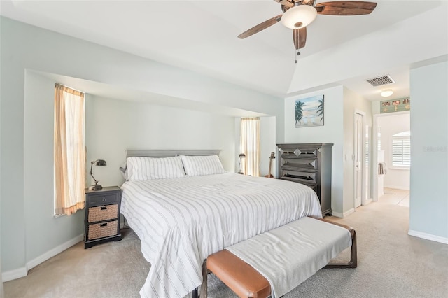 carpeted bedroom with ensuite bathroom and ceiling fan