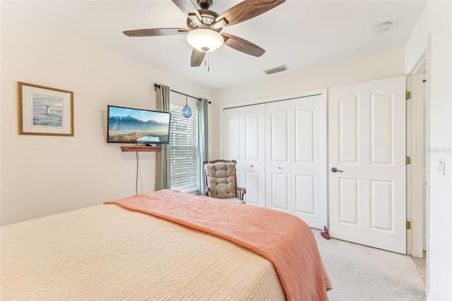 bedroom with ceiling fan, a closet, and light colored carpet