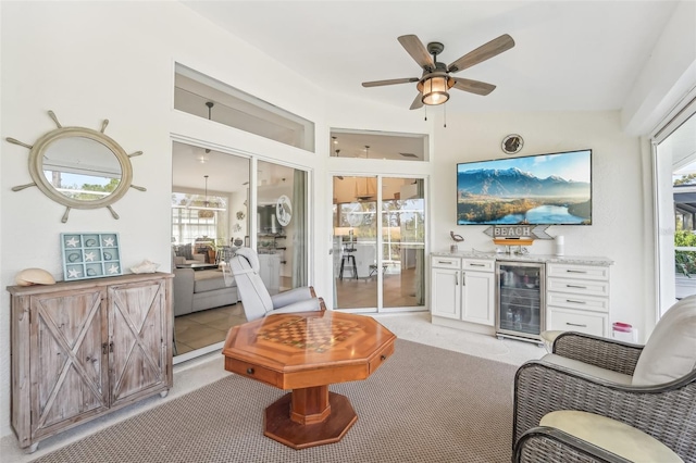 carpeted living room with bar, plenty of natural light, beverage cooler, and ceiling fan