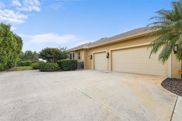 view of side of home with a garage and central air condition unit