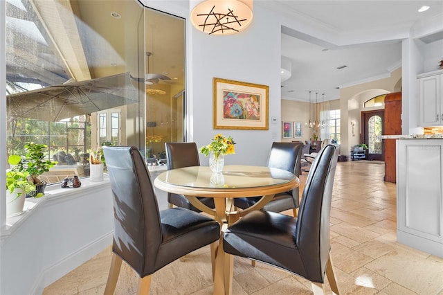 dining space featuring plenty of natural light and crown molding