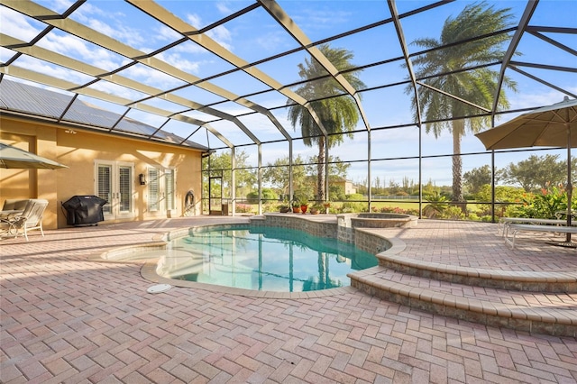 view of swimming pool featuring area for grilling, glass enclosure, an in ground hot tub, and a patio area