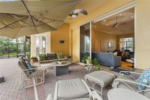 view of patio / terrace with a lanai, french doors, ceiling fan, and an outdoor living space