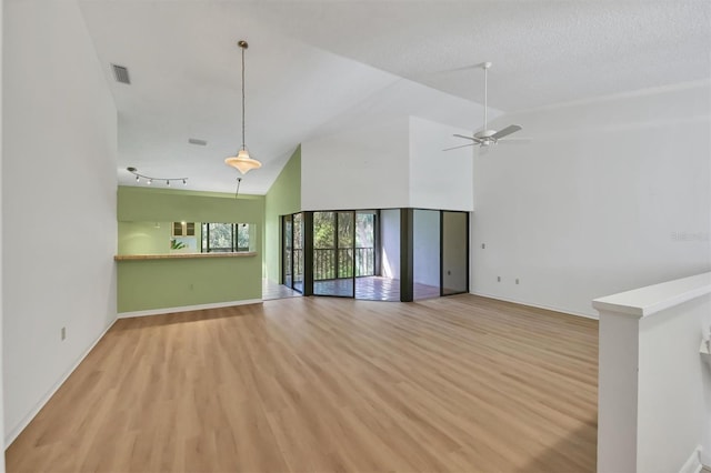 unfurnished living room with a textured ceiling, light hardwood / wood-style flooring, high vaulted ceiling, and ceiling fan