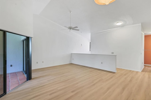 unfurnished living room with ceiling fan, high vaulted ceiling, and light wood-type flooring