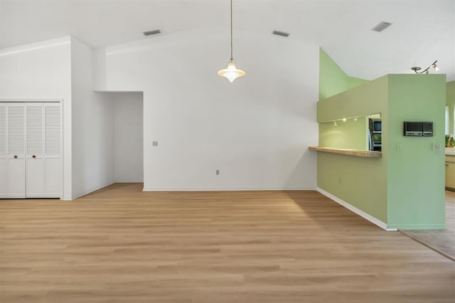 unfurnished living room with high vaulted ceiling and light hardwood / wood-style flooring