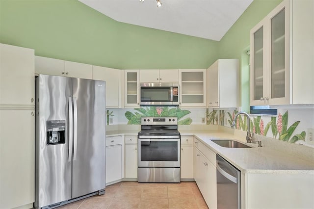 kitchen with light tile patterned flooring, sink, white cabinetry, stainless steel appliances, and decorative backsplash