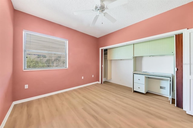 unfurnished bedroom featuring ceiling fan, a closet, a textured ceiling, and light hardwood / wood-style flooring