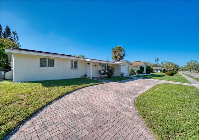 single story home featuring a garage and a front yard