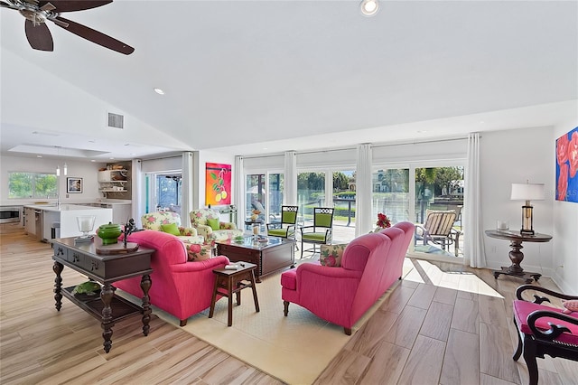 living room with light wood-type flooring, high vaulted ceiling, a wealth of natural light, and ceiling fan