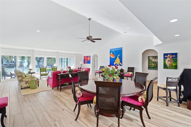 dining space with ceiling fan, lofted ceiling, and light wood-type flooring