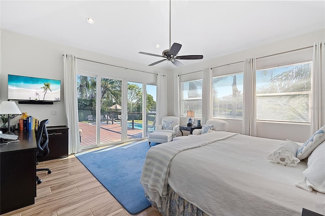 bedroom featuring ceiling fan, access to exterior, light hardwood / wood-style flooring, and multiple windows