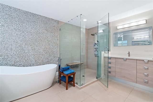 bathroom with tile patterned flooring, vanity, tile walls, and independent shower and bath