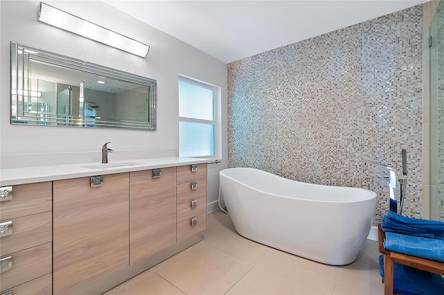 bathroom featuring tile patterned flooring, vanity, tile walls, and a tub