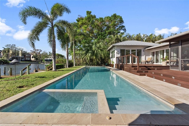 view of swimming pool featuring a sunroom and a deck with water view