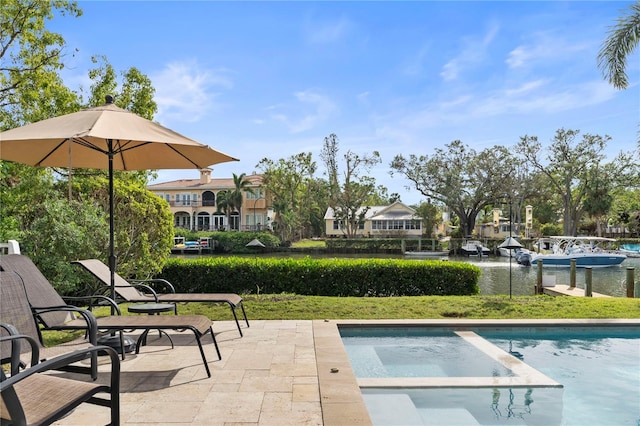 view of swimming pool featuring a lawn, a water view, and a patio