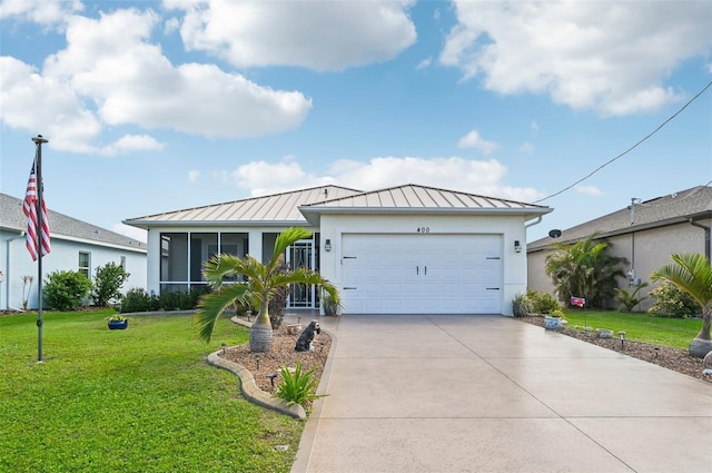 view of front of house with a sunroom, a garage, and a front lawn