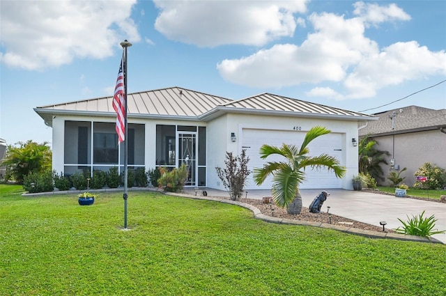 view of front of house with a sunroom, a front lawn, and a garage