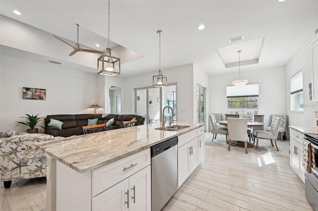 kitchen featuring sink, white cabinets, stainless steel appliances, and decorative light fixtures