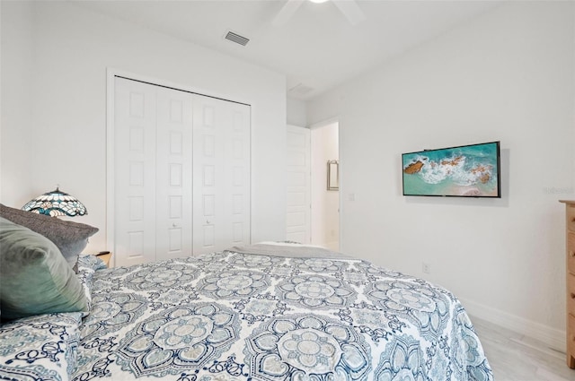 bedroom featuring ceiling fan, light hardwood / wood-style flooring, and a closet