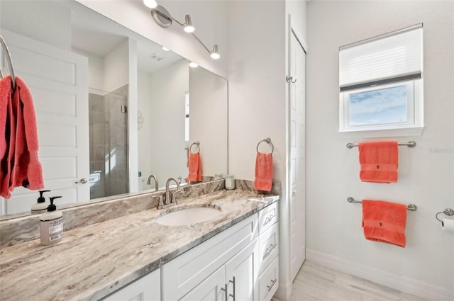 bathroom featuring vanity, hardwood / wood-style flooring, and a shower with shower door