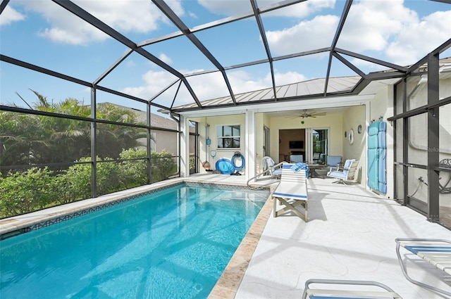 view of swimming pool with ceiling fan, a patio area, and a lanai